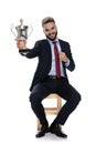 Happy young businessman holding trophy and smiling Royalty Free Stock Photo