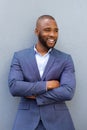 Happy young businessman leaning against wall with his arms crossed Royalty Free Stock Photo