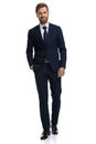 Happy young businessman in navy blue suit walking and smiling Royalty Free Stock Photo