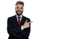 Happy young businessman pointing finger to side and smiling Royalty Free Stock Photo