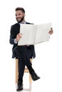 Happy young businessman reading newspaper and laughing Royalty Free Stock Photo