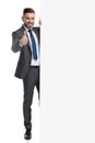 Happy young businessman recommends with thumbs up a message Royalty Free Stock Photo
