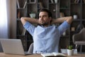 Happy young businessman relaxing in modern office room. Royalty Free Stock Photo