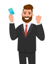 Happy young businessman showing credit, debit, ATM card. Man making raised hand fist gesture. Male character design illustration.