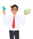 Happy young businessman showing credit, debit, ATM card. Person holding bunch of cash, money, currency notes in hand. Royalty Free Stock Photo