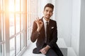 Happy young businessman showing ok sign over office background Royalty Free Stock Photo