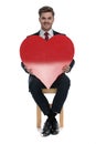 Happy young businessman smiling and holding big red heart Royalty Free Stock Photo