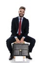 Happy young businessman smiling and holding suitcase Royalty Free Stock Photo