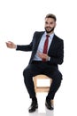 Happy young businessman smiling and presenting to side Royalty Free Stock Photo