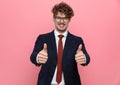 Happy young businessman in suit making thumbs up sign Royalty Free Stock Photo