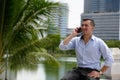 Happy young businessman talking on the phone at the park Royalty Free Stock Photo