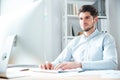 Happy young businessman using laptop computer in office Royalty Free Stock Photo