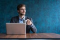 Happy young businessman using laptop at his office desk. Royalty Free Stock Photo