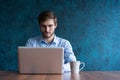 Happy young businessman using laptop at his office desk. Royalty Free Stock Photo