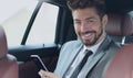 Happy young businessman using mobile phone in back seat of car Royalty Free Stock Photo