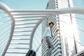 Happy Young Businessman Using Mobile Phone while Walking with Suitcase in the City. Lifestyle of Modern People. Low Angle View. Royalty Free Stock Photo