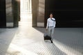 Happy Young Businessman Walking with Suitcase in the City. Modern Male in Business Trip. Front View