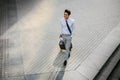 Happy Young Businessman Walking with Suitcase in the City. Modern Male in Business Trip. High Angle View Royalty Free Stock Photo
