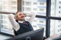 Happy young businessman work in modern office relaxing in chair, lifestyle after work at office Royalty Free Stock Photo