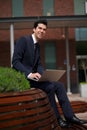 Happy young businessman working outdoors with laptop Royalty Free Stock Photo