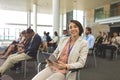 Happy young businesswoman with digital tablet looking at camera during seminar Royalty Free Stock Photo