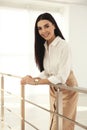 Happy young businesswoman leaning on railing in office Royalty Free Stock Photo