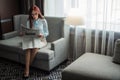 Happy young businesswoman reading newspaper in hotel lobby Royalty Free Stock Photo