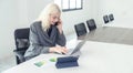 Happy young businesswoman using laptop in conference room Royalty Free Stock Photo