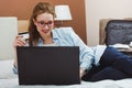 Happy young businesswoman using tablet pc in hotel room. Online shopping with credit card. Royalty Free Stock Photo