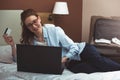 Happy young businesswoman using tablet pc in hotel room. Online shopping with credit card. Royalty Free Stock Photo