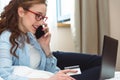 Happy young businesswoman using tablet pc in hotel room. Online shopping with credit card. Royalty Free Stock Photo