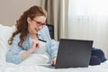 Happy young businesswoman using tablet pc in hotel room. Online shopping with credit card. Royalty Free Stock Photo