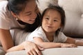 Happy young caring vietnamese mommy cuddling funny baby girl. Royalty Free Stock Photo