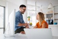 Happy young casual couple sitting at desk working together at home office Royalty Free Stock Photo