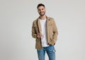 Happy young casual guy in jacket holding hand in pocket Royalty Free Stock Photo