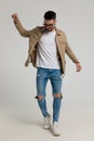Happy young casual guy in jacket looking down and walking Royalty Free Stock Photo