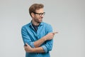 Happy young casual man looking to side and pointing finger Royalty Free Stock Photo