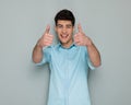 happy young casual man making thumbs up sign and smiling Royalty Free Stock Photo