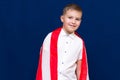 Happy young caucasian american boy kid child schoolboy wraps himself in a U.S. flag and look at camera Royalty Free Stock Photo