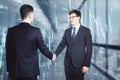 Happy young caucasian businessmen with glowing forex chart shaking hands on blurry office interior background. Trade and