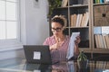 Happy young caucasian businesswoman smiling working online watching webinar podcast on laptop and learning education course Royalty Free Stock Photo