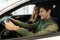 Happy young Caucasian couple driving their new car, sitting inside luxury auto, copy space Royalty Free Stock Photo