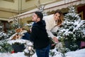 Happy young couple having fun on winter cityscape background of christmas tree with lights. Winter holidays, Christmas Royalty Free Stock Photo