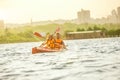 Happy couple kayaking on river with sunset on the background Royalty Free Stock Photo