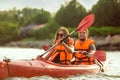 Happy couple kayaking on river with sunset on the background Royalty Free Stock Photo