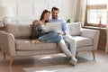 Happy couple relax on sofa using laptop together