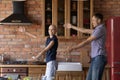 Happy young man with sick wife dance in kitchen