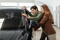 Happy young Caucasian family choosing new car at automobile dealership store Royalty Free Stock Photo