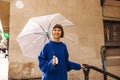 Happy young caucasian girl holding umbrella smiling looking at camera outdoors. Royalty Free Stock Photo