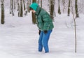 A happy young Caucasian girl walks in the snow in the winter forest. A lonely girl walks through snowdrifts on a clear frosty wint